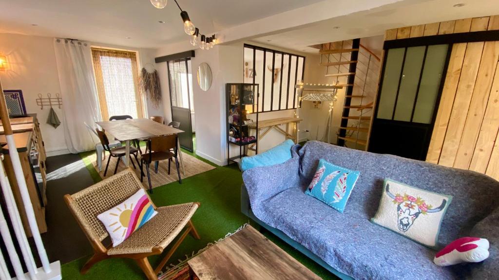 - un salon avec un canapé bleu et une table dans l'établissement La MaisonneTTe d'ElodibiZa !, à Moret-sur-Loing