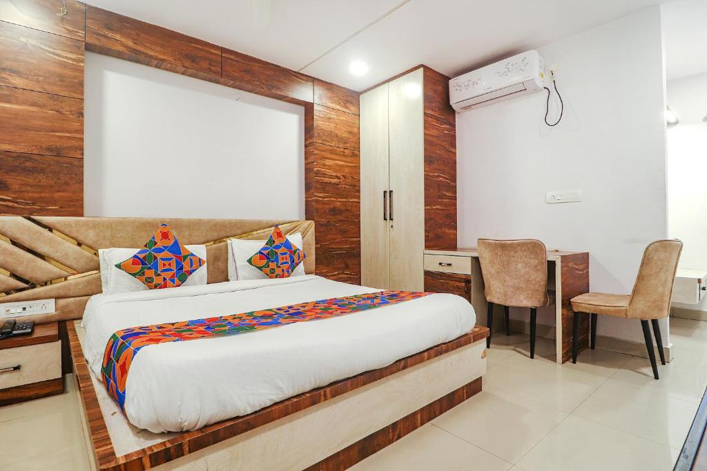 a bedroom with a bed and a desk and a chair at FabHotel Double Tree in Hyderabad