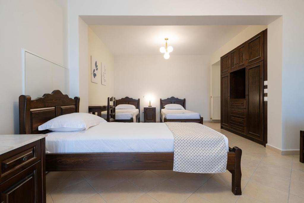 a bedroom with two beds and a dresser at Amigdalies in Myrina