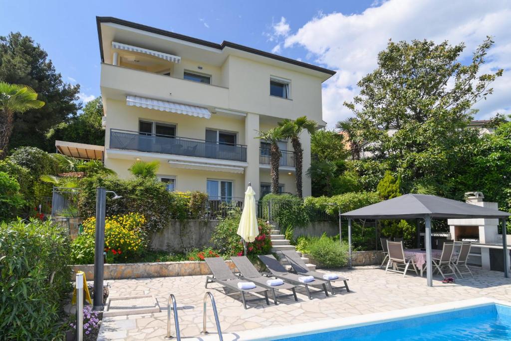 uma villa com piscina e um edifício em Apartments Grozic Opatija em Opatija