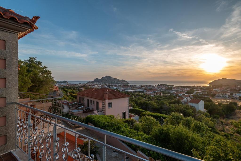 a view from the balcony of a house with the sunset at Amigdalies in Myrina
