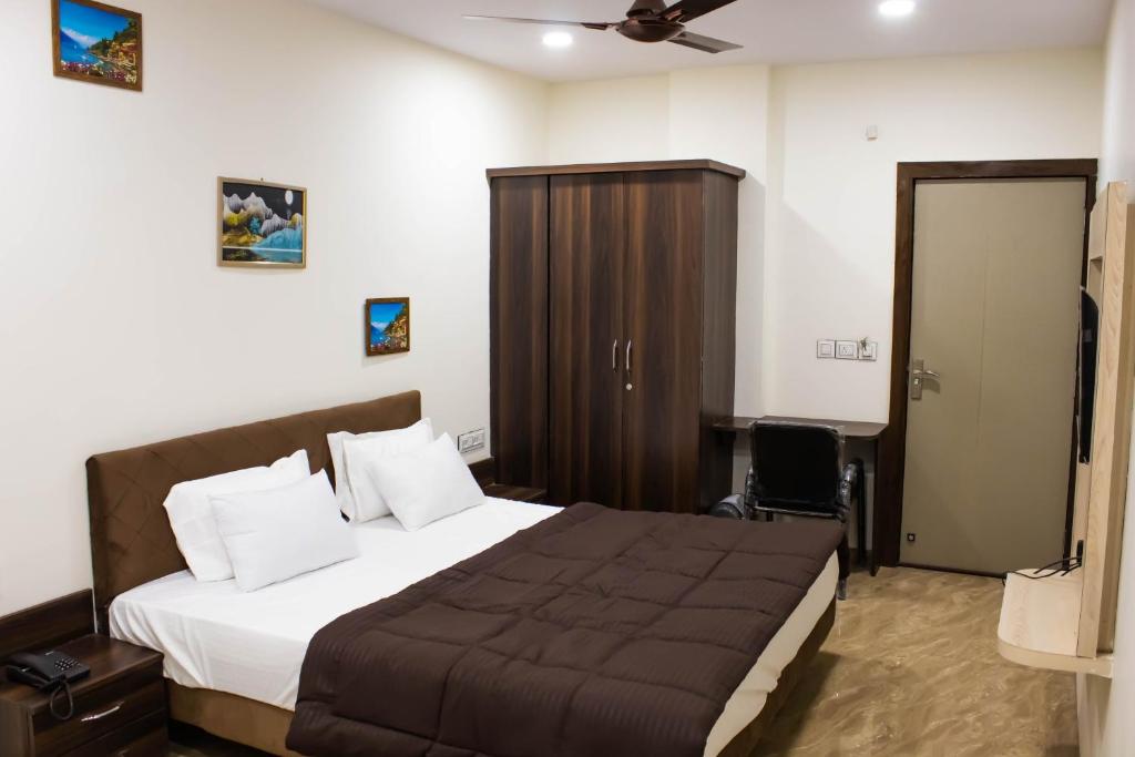 a bedroom with a large bed and a brown closet at Hotel Kiwi Inn in Indore