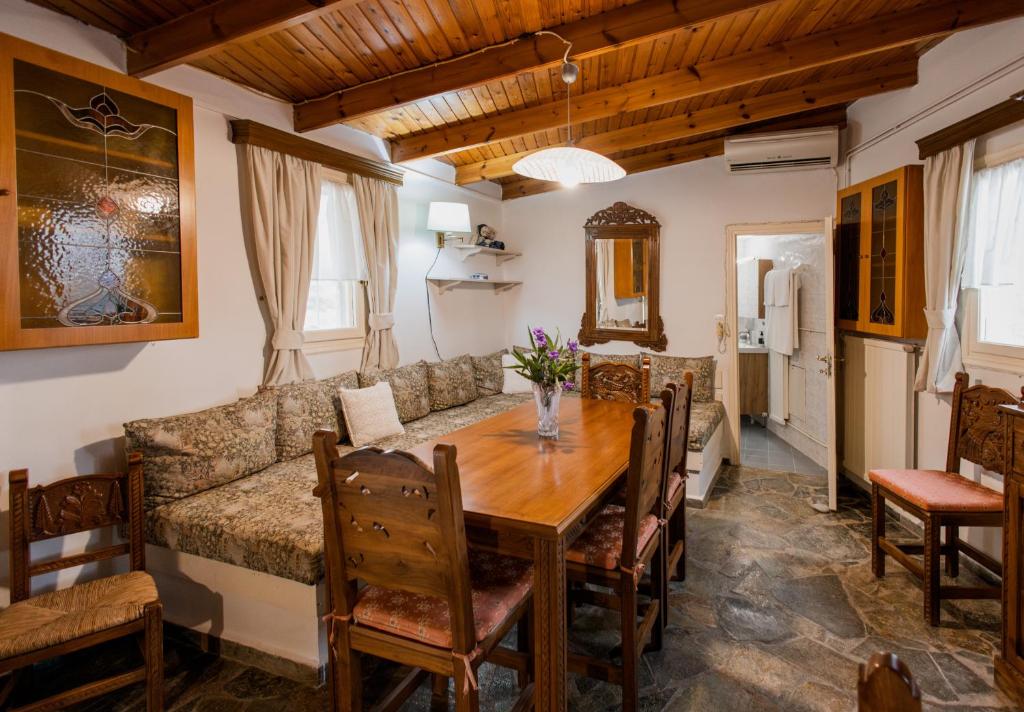 a dining room with a table and a couch at Minas Farm Cottage in Gouves