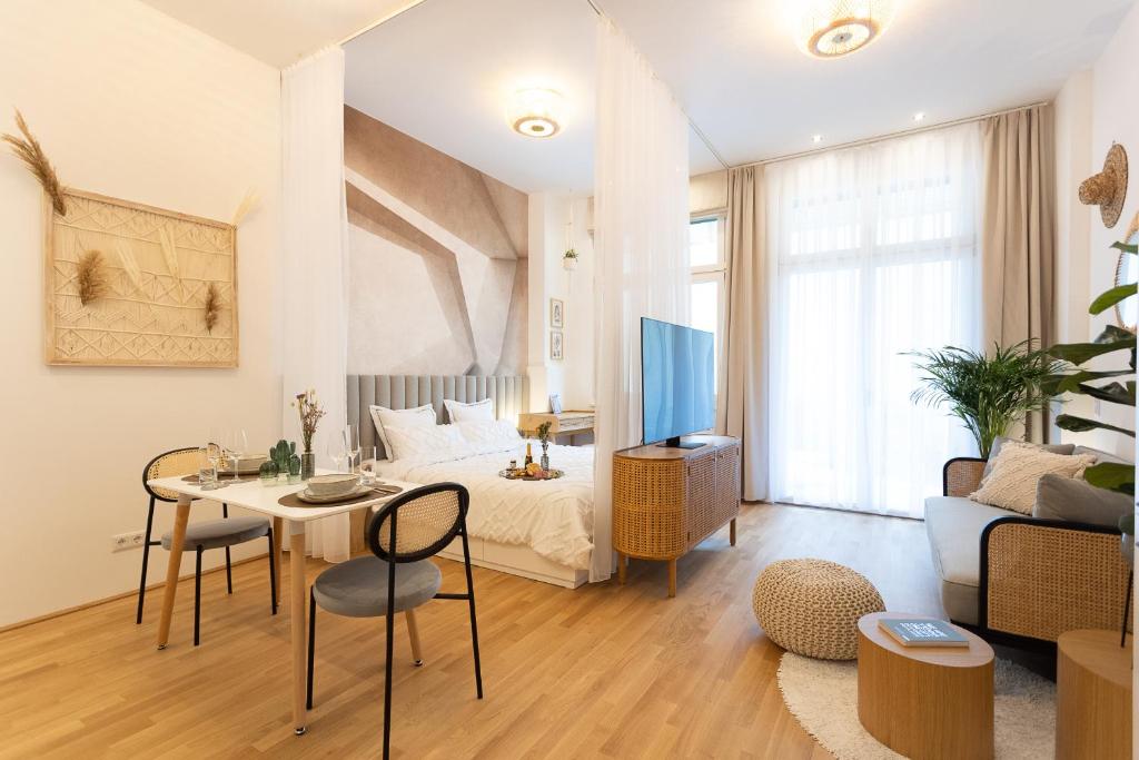 een kamer met een bed, een tafel en een tv bij The Bohemian Courtyard Studios in Wenen