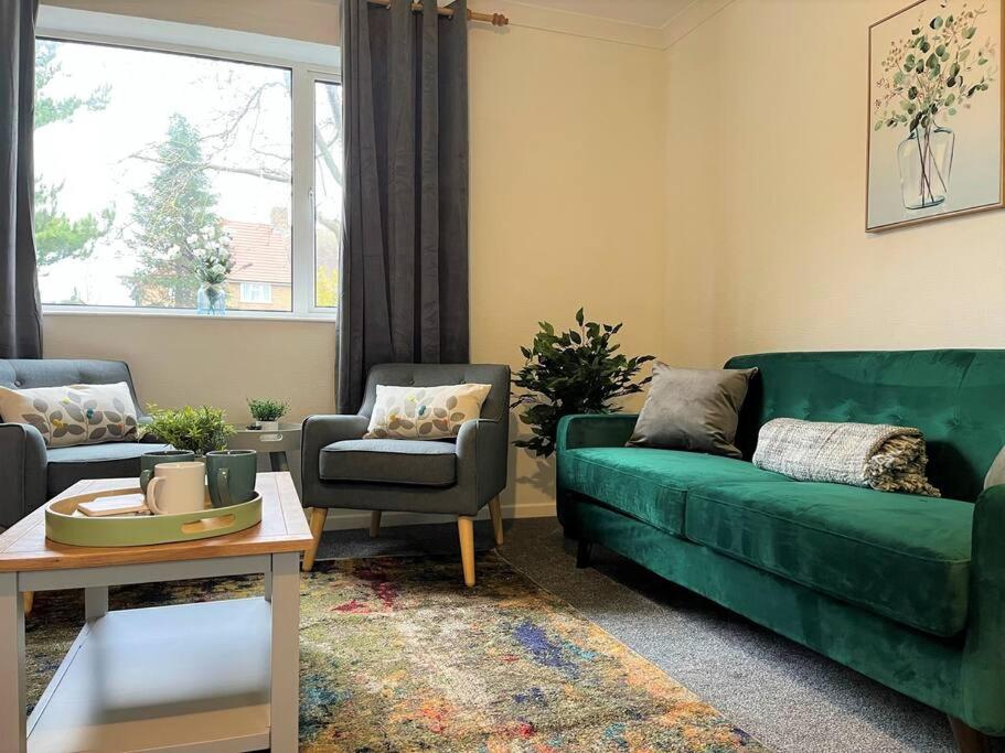 a living room with a green couch and chairs at Charming 3-bed Home In Bourne in Lincolnshire