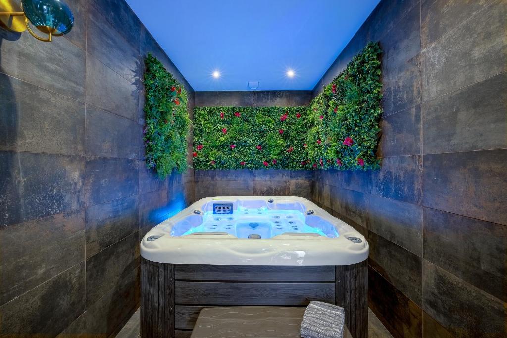 a bathroom with a jacuzzi tub with plants on the wall at Jacuzzi, Mer 3 min, B&B in Nice