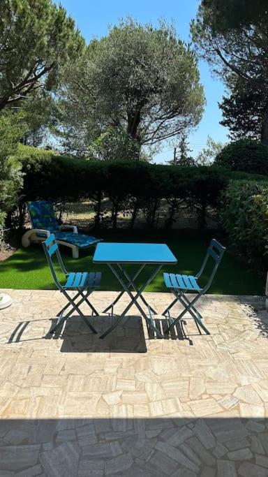 - une table de pique-nique bleue et 2 chaises sur la terrasse dans l'établissement Studio climatisé avec piscine-tennis-parking, à Villeneuve-Loubet