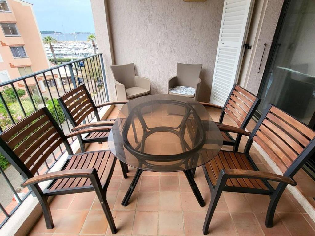 un patio avec une table et des chaises sur un balcon dans l'établissement T2 avec piscine, tennis, parking - 200m plage, commerces - FR-1-316-118, à Six-Fours-les-Plages