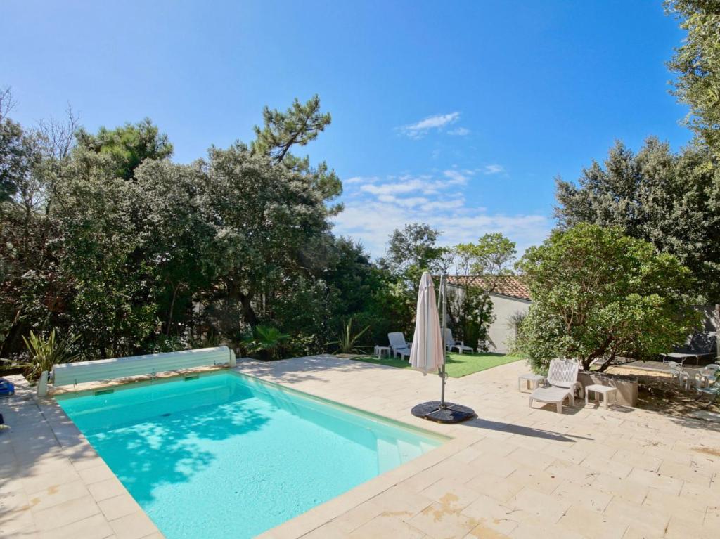 una piscina en un patio con sombrilla en Maison calme aperçu mer avec piscine privée à 28, en Saint-Palais-sur-Mer
