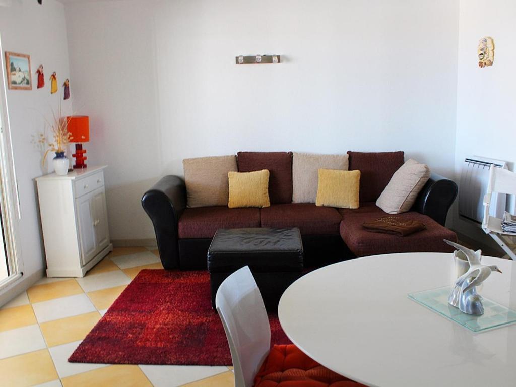 un salon avec un canapé et une table dans l'établissement Spacieux T4 climatisé avec parking au cœur de Rochelongue - FR-1-607-29, au Cap d'Agde