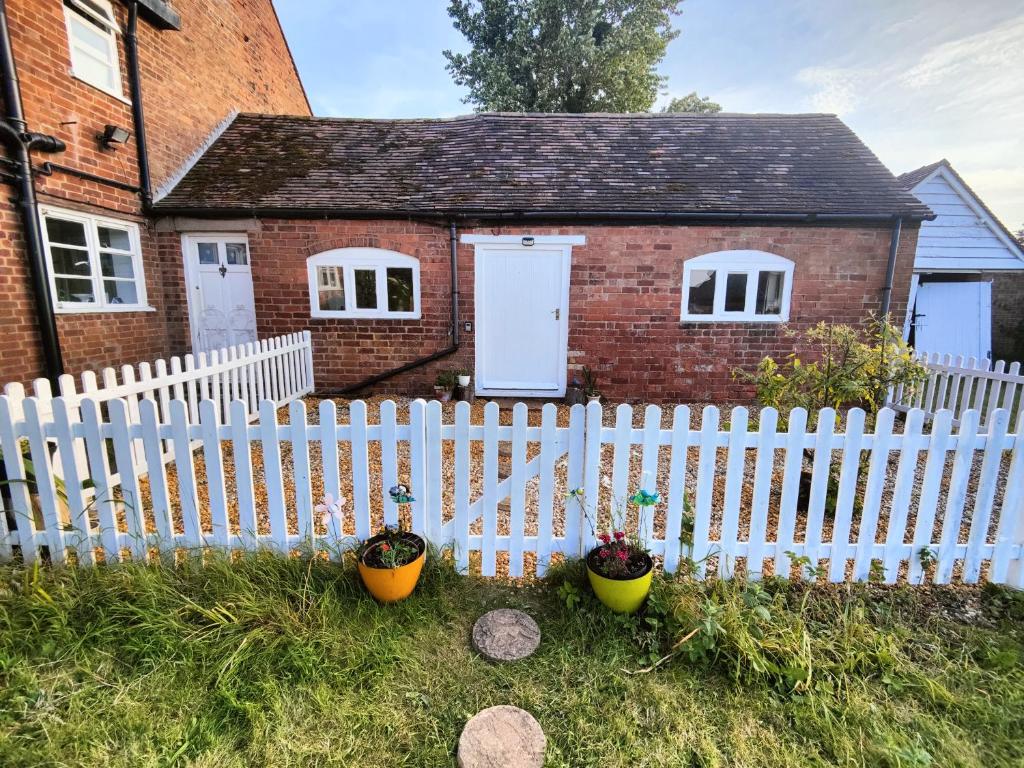 a white fence in front of a house at The Dairy in Pershore