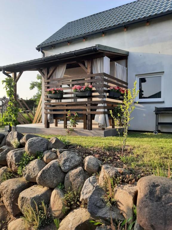 a house with a pergola and a stone wall at Bliźniaki u Very in Łagów