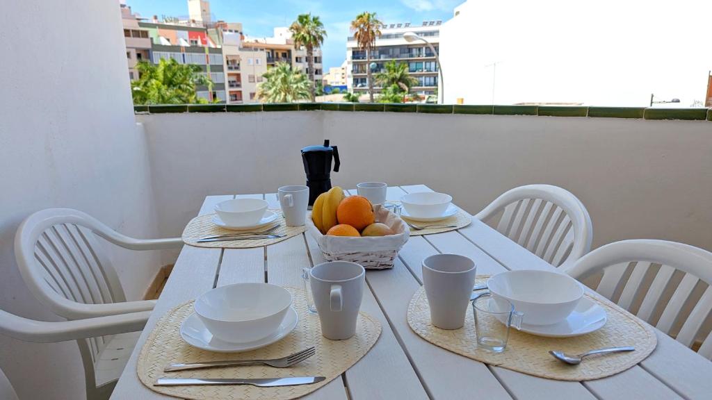 una mesa blanca con un bol de fruta en el balcón en La Palmera - Apartamento a 600mt de la playa - Los Cristianos, en Los Cristianos