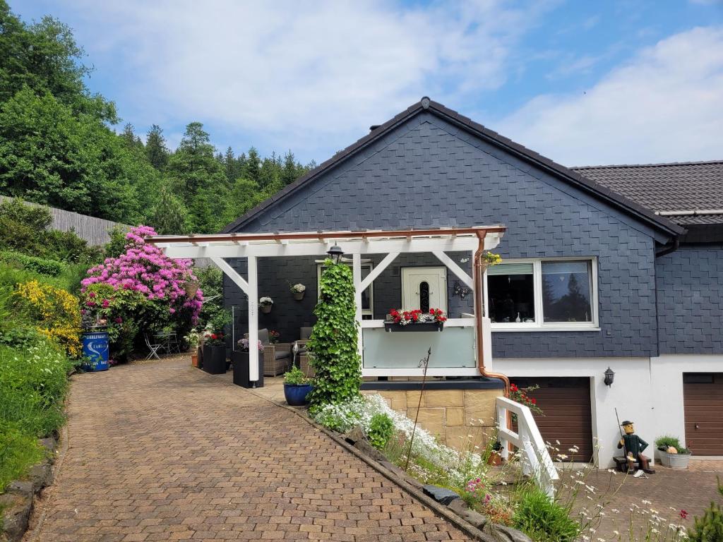 a house with a pergola on the side of it at Gästezimmer Haus Talblick in Lautenthal