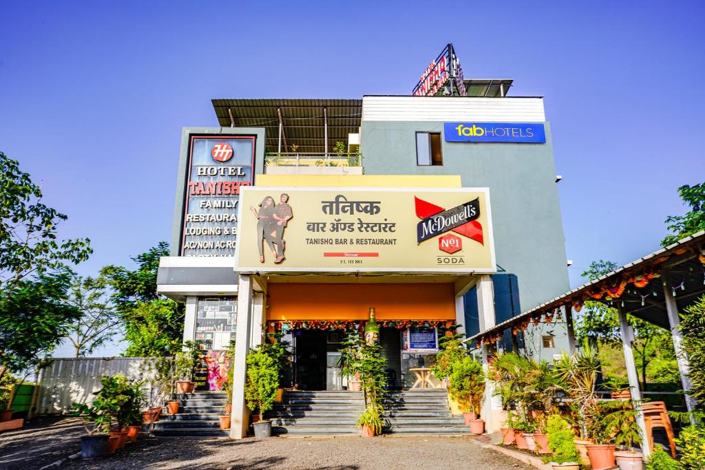 a building with a sign on the front of it at FabHotel Tanishq in Sinnar