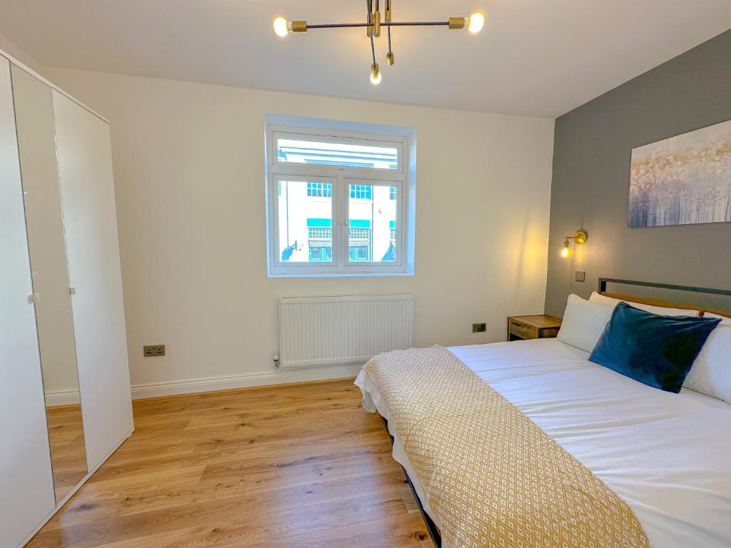 Un dormitorio con una gran cama blanca y una ventana en Parkway residences, en Londres