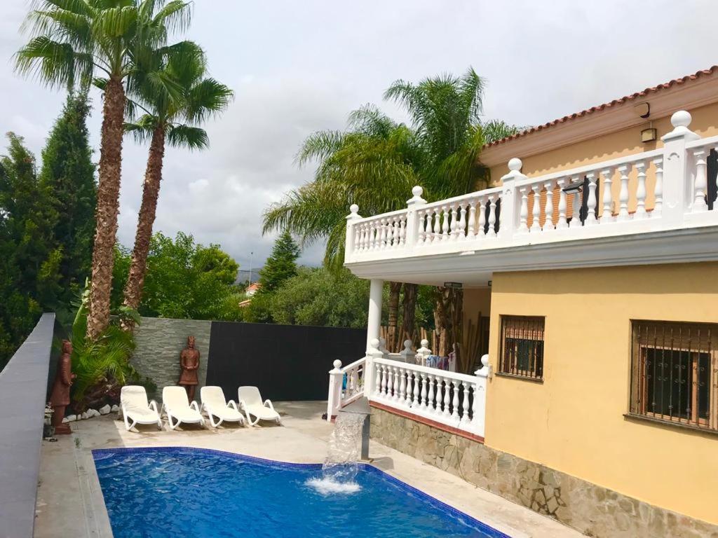 una casa con piscina di fronte a una casa di Villa Holiday a Castellón de la Plana