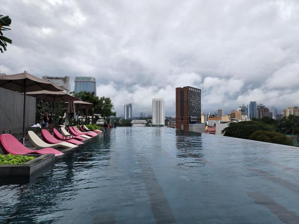 - une piscine avec des chaises longues au-dessus d'un bâtiment dans l'établissement opus residences by sunflower, à Kuala Lumpur