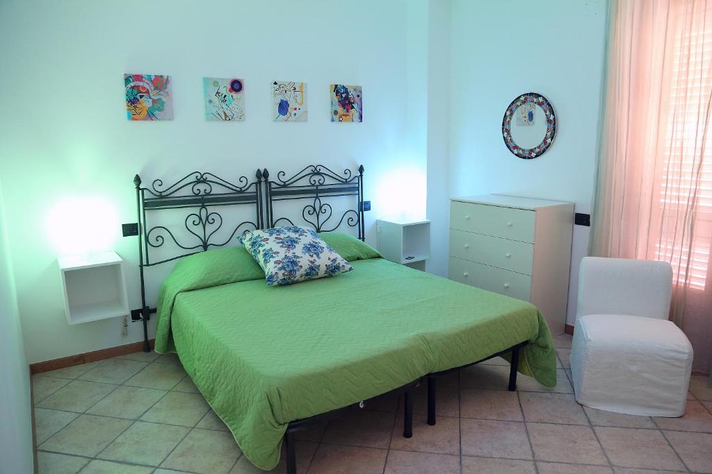 een slaapkamer met een groen bed en een stoel bij Normanni 28 - Private and Guest House in Campagna