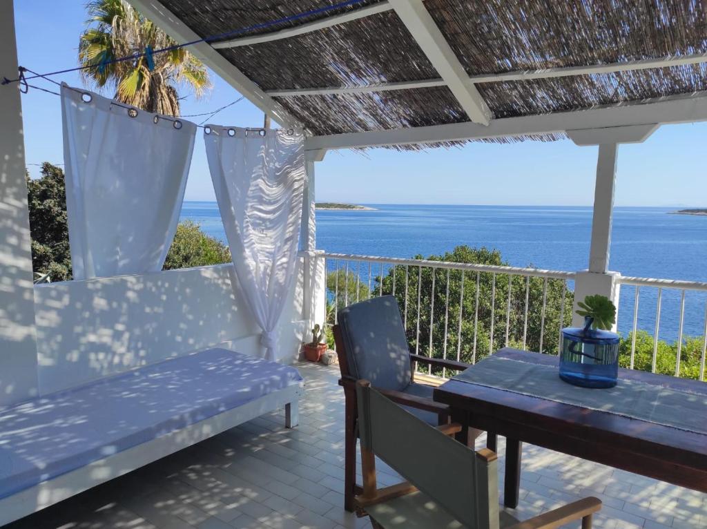 a patio with a table and chairs and the ocean at Getaway house Gundula in Podstražje