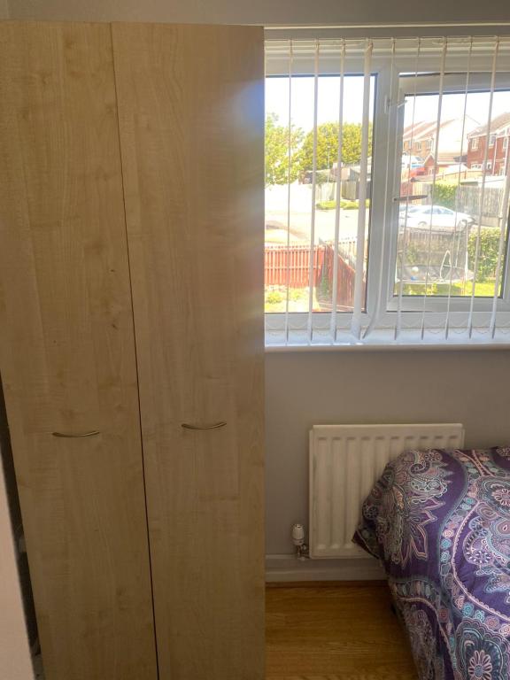 ein Schlafzimmer mit einem großen Holzschrank neben einem Fenster in der Unterkunft LivingWater in Manor
