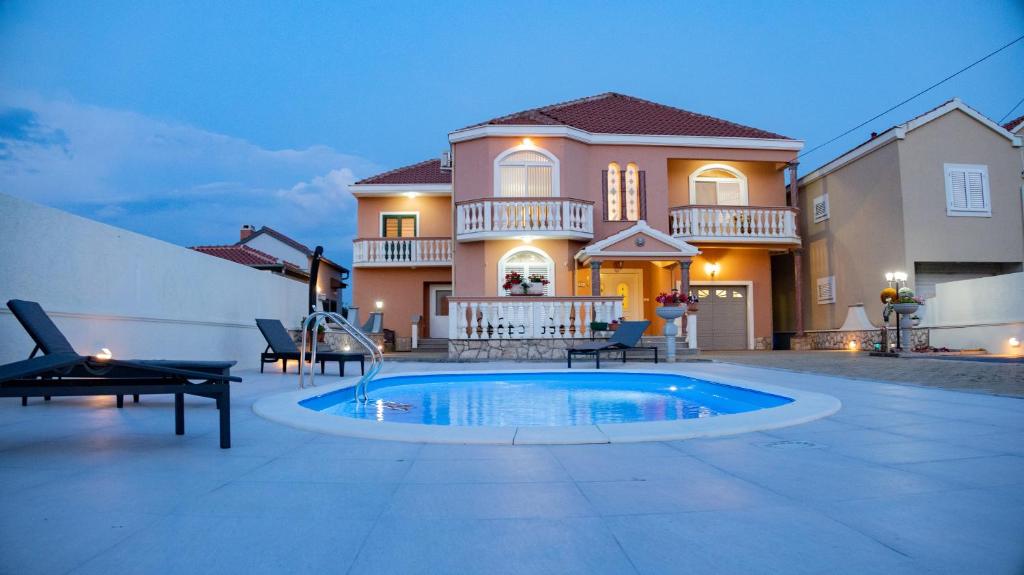ein Haus mit einem Pool vor einem Haus in der Unterkunft Booking Zaton Villa Martinova holiday house with swimming pool in Zaton