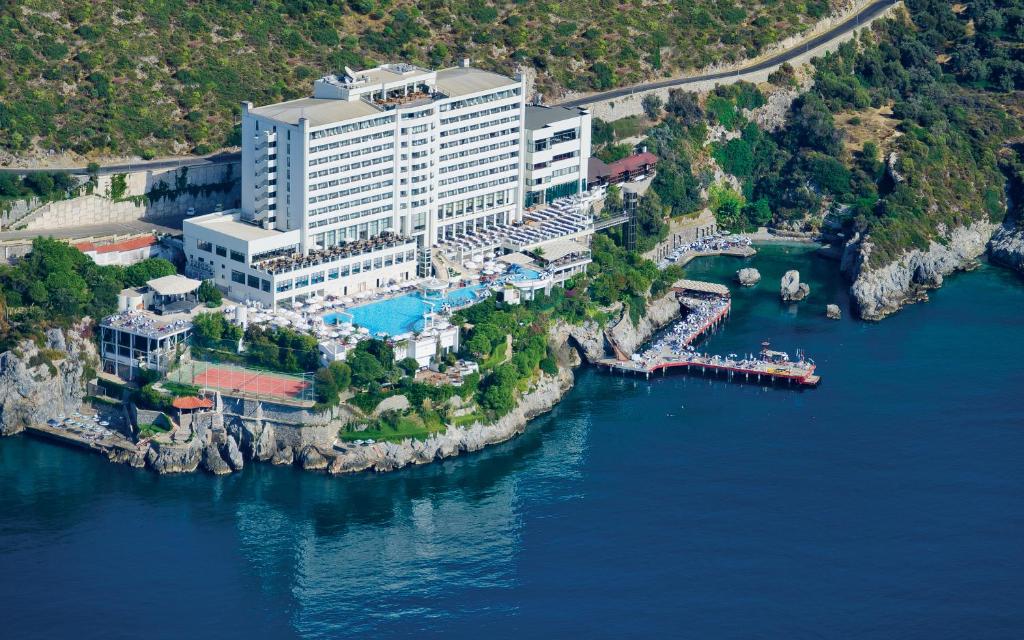 an aerial view of a hotel on the water at Korumar Hotel Deluxe in Kuşadası