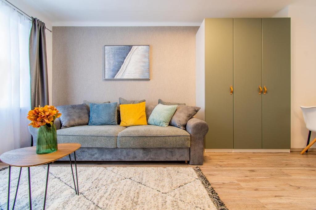 uma sala de estar com um sofá e uma mesa em Alex Apartman em Szombathely