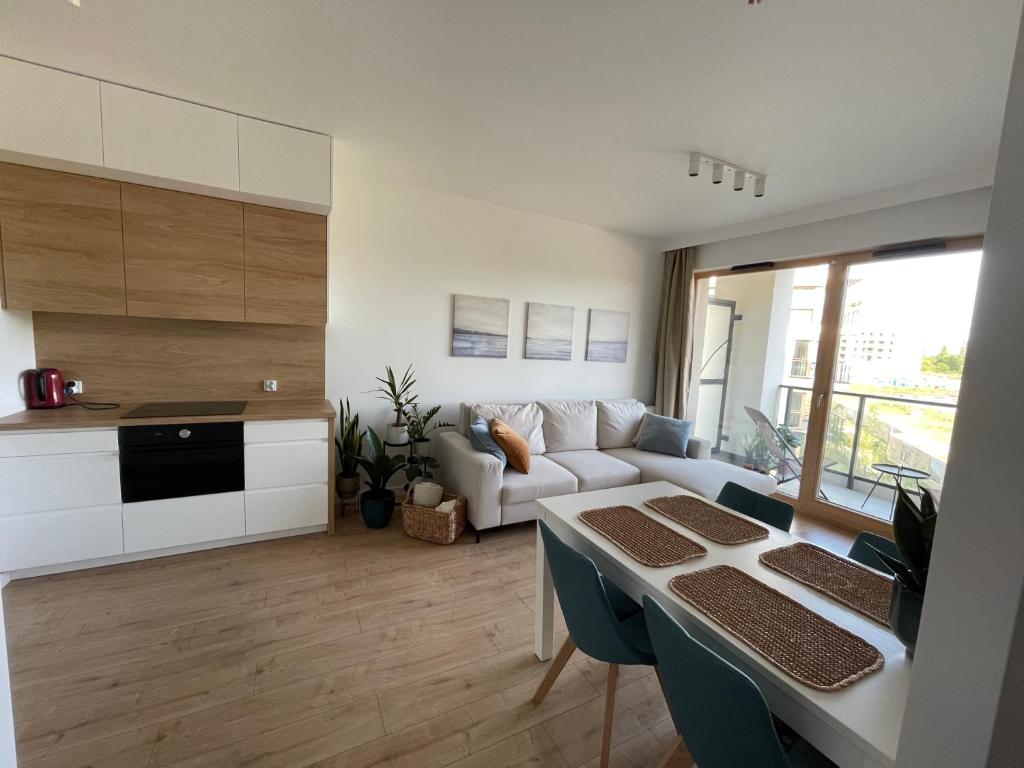 een woonkamer met een witte bank en een tafel bij Sun&Sand11 in Gdańsk