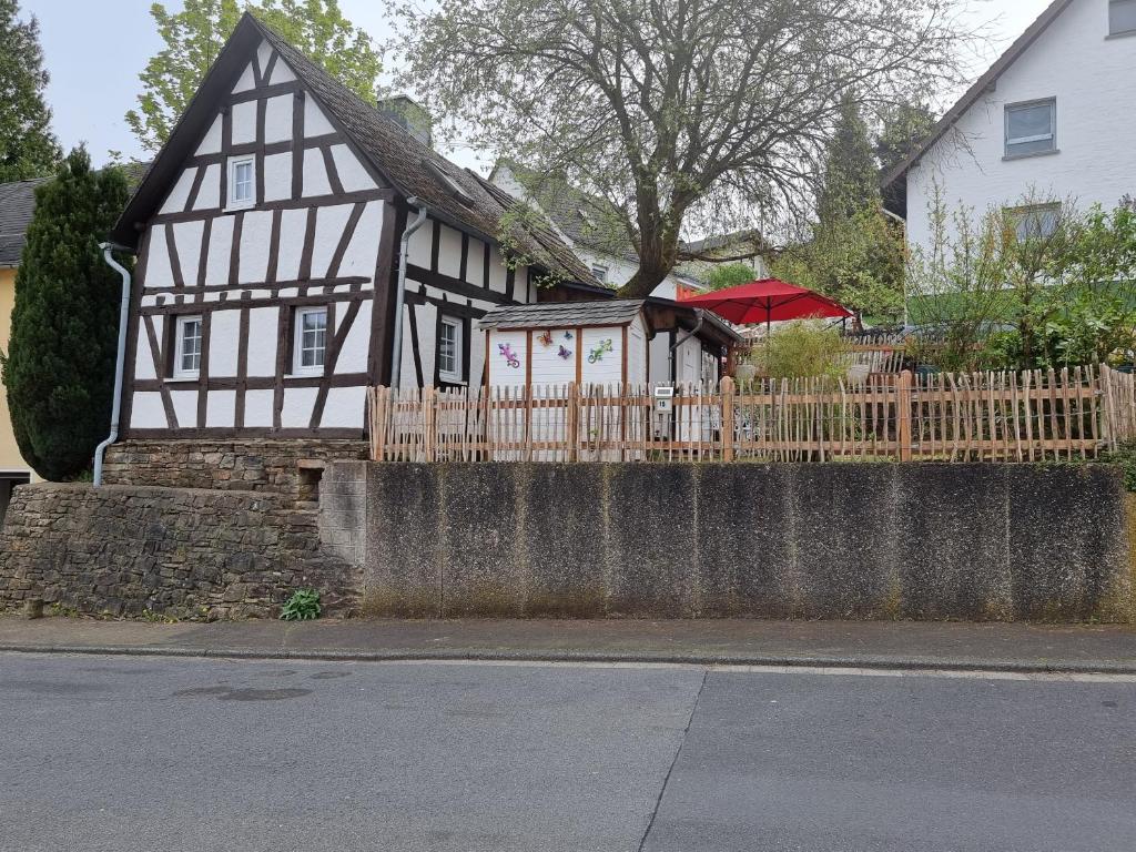 una casa en blanco y negro con una valla de madera en Fachwerkhaus Hänsel und Gretel, en Hundsdorf