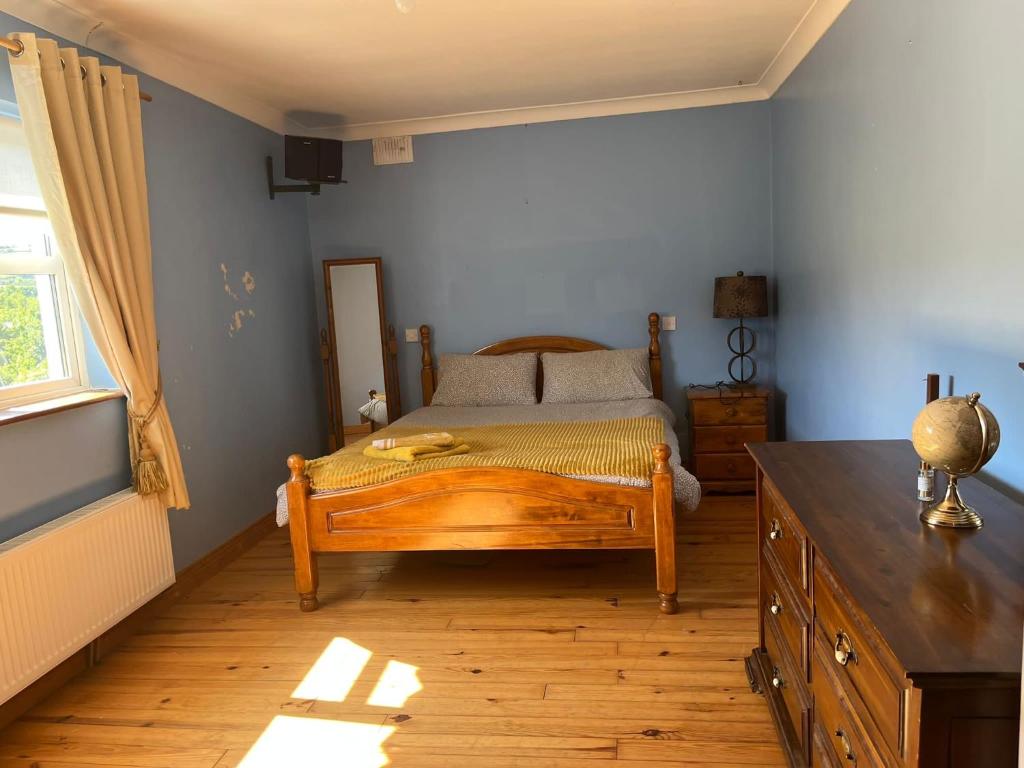graiguenamanagh Homestay في Graiguenamanagh: غرفة نوم بسرير خشبي مع دولاب خشبي