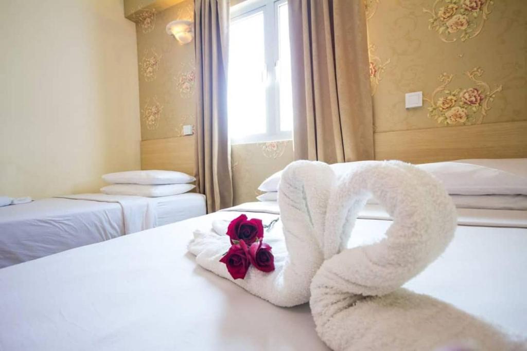 Hotel Sea Princess في تيلوك بهانج: غرفة في الفندق مع منشفة مغلفة حول سرير