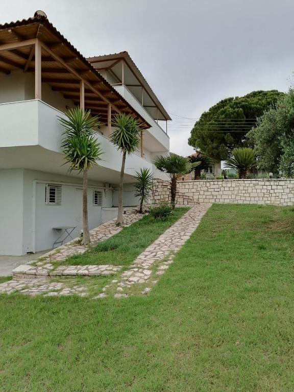 a house with palm trees in front of a yard at Panoramic view in Preveza