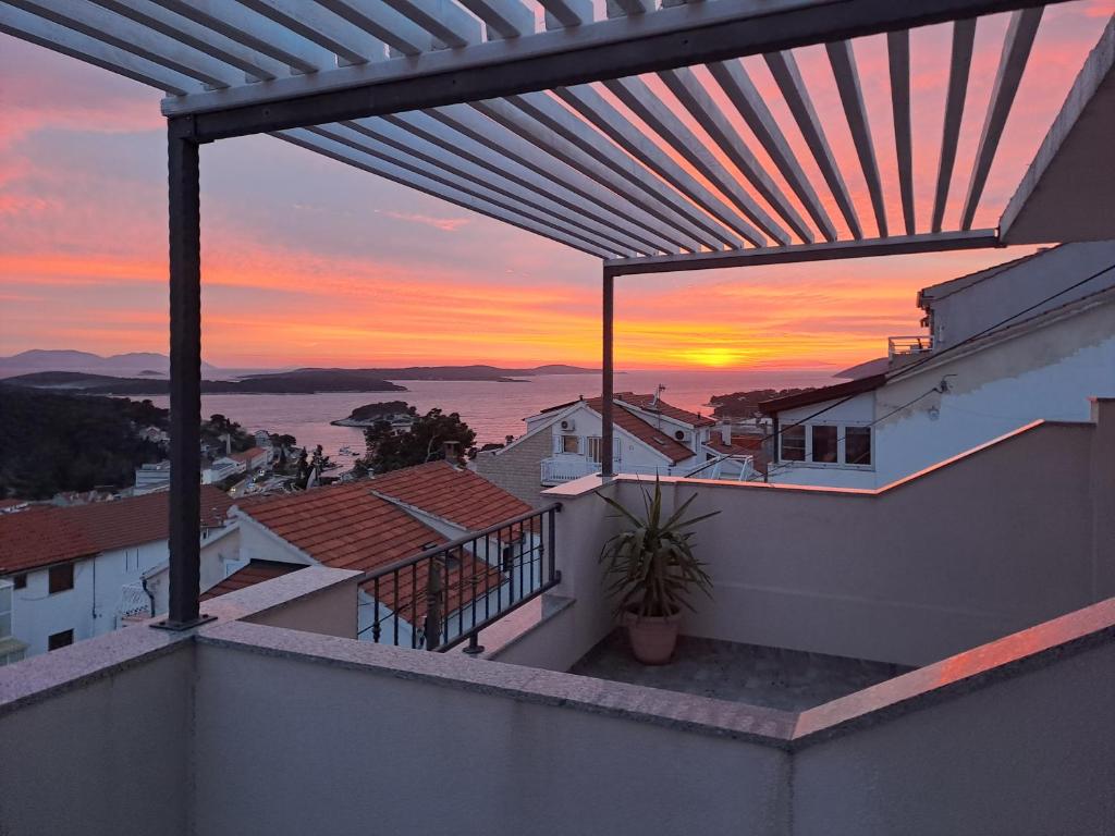 een balkon met uitzicht op de zonsondergang bij BenJak Apartments in Hvar