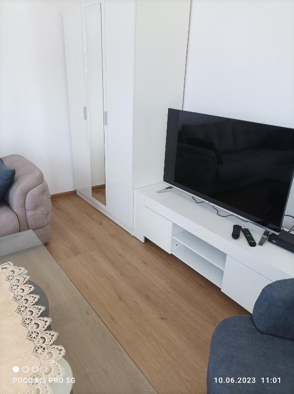a living room with a flat screen tv on a white table at Winnica u Mirki in Gurkovo