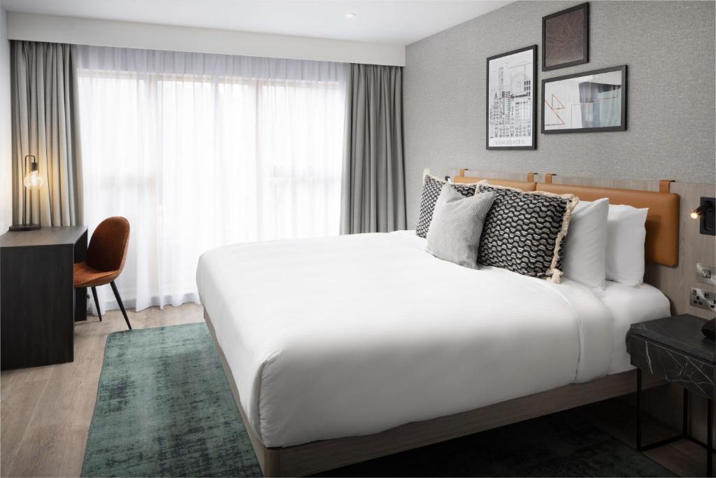 Un dormitorio con una gran cama blanca y una ventana en Residence Inn by Marriott Manchester Piccadilly en Mánchester