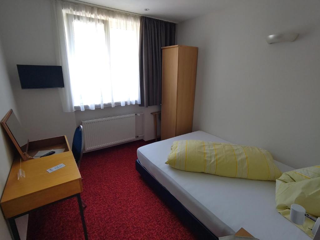 a hotel room with a bed and a window at Hotel im Klosterring in Villingen-Schwenningen