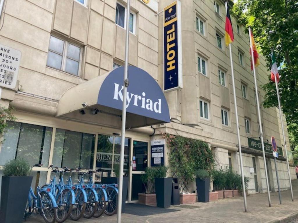 ein Hotel mit Fahrrädern, die vor einem Gebäude geparkt sind in der Unterkunft Kyriad Hotel Montpellier Centre Antigone in Montpellier