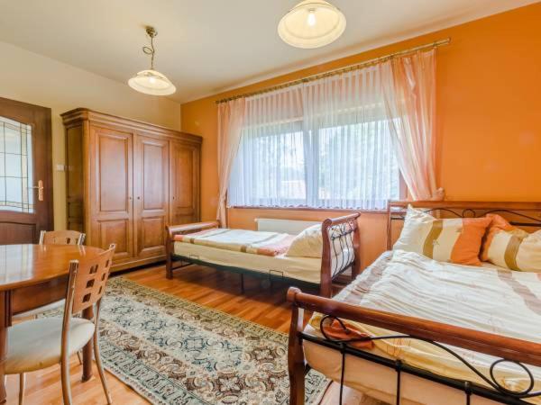 sypialnia z 2 łóżkami i stołem oraz jadalnia w obiekcie Apartament II Marysieńka w Kątach Rybackich