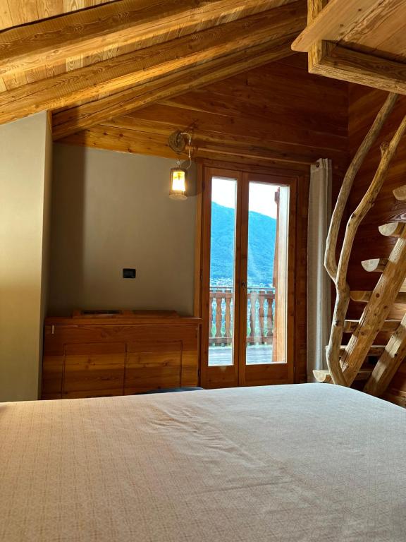 una camera con un grande letto e una finestra di LA PIANA DAL SAS a Gravellona Toce