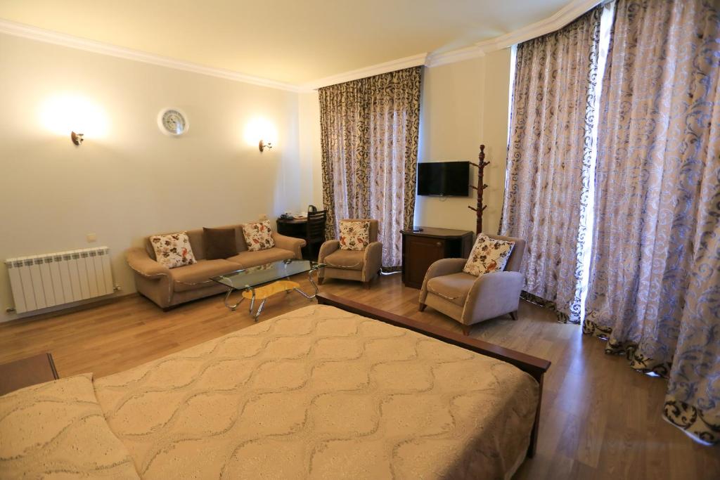 a living room with a couch and two chairs at Eiffel Hotel in Batumi