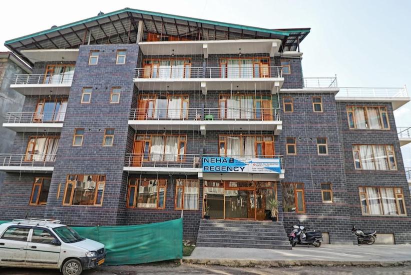 un bâtiment avec une voiture garée devant lui dans l'établissement Hotel Neha Regency, à Manali