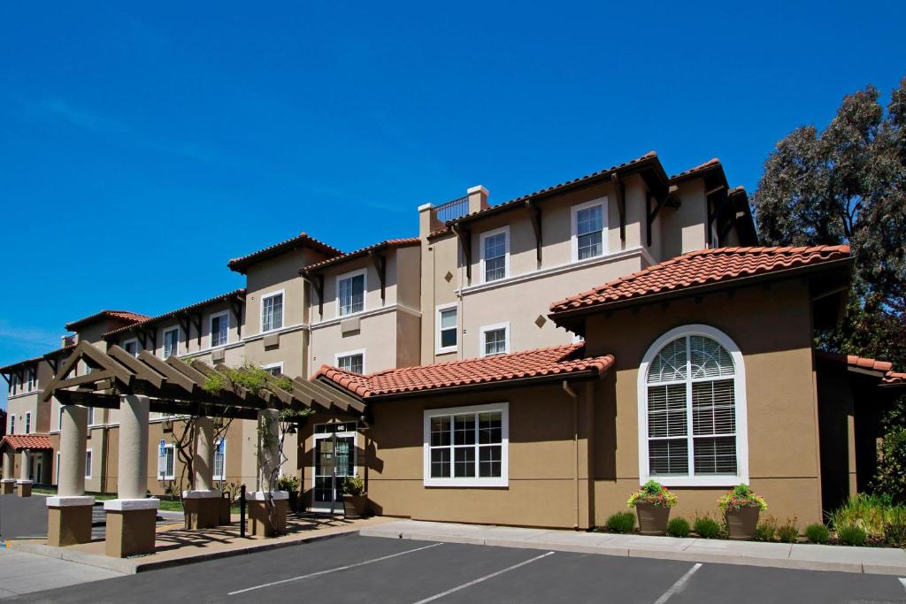 un grand immeuble d'appartements avec un parking dans l'établissement TownePlace Suites San Jose Cupertino, à San José
