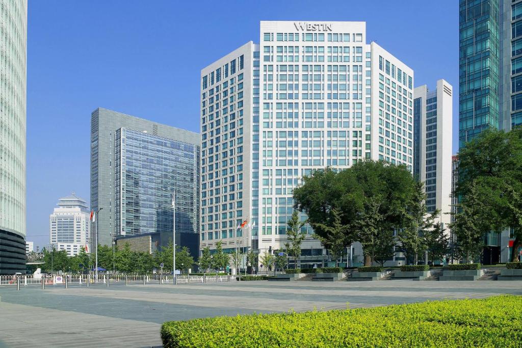 a large white building in a city with tall buildings at The Westin Beijing Financial Street in Beijing