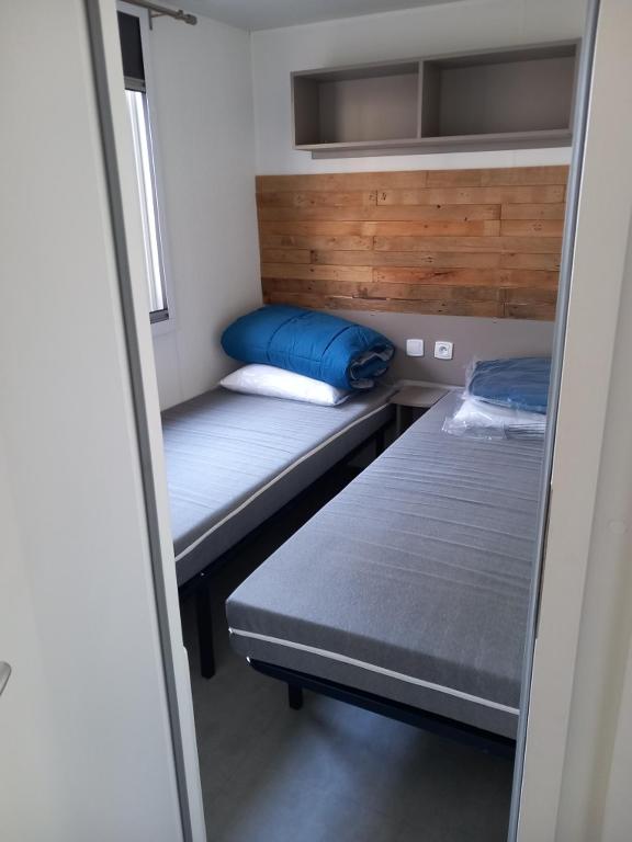 a small room with two beds in a room at Mobil-home Les Dunes de Contis in Saint-Julien-en-Born
