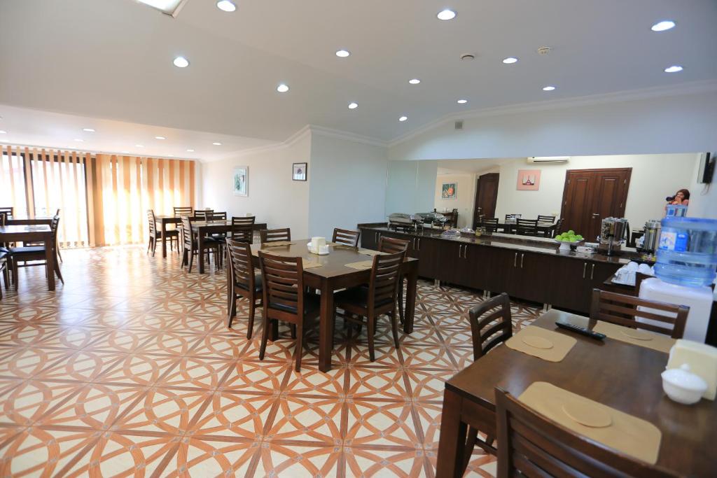 a restaurant with tables and chairs in a room at Eiffel Hotel in Batumi