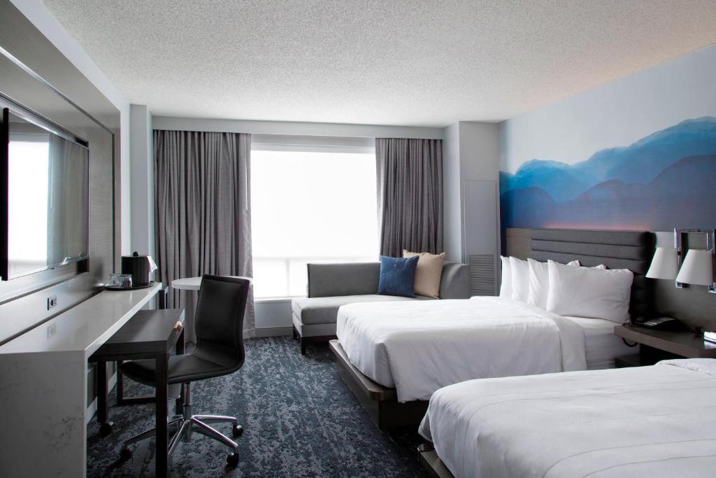 a hotel room with two beds and a desk at Franklin Marriott Cool Springs in Franklin