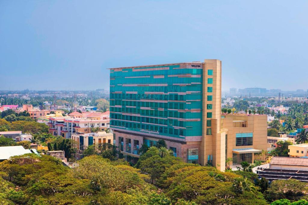 a tall blue building on top of a city at The Westin Chennai Velachery in Chennai