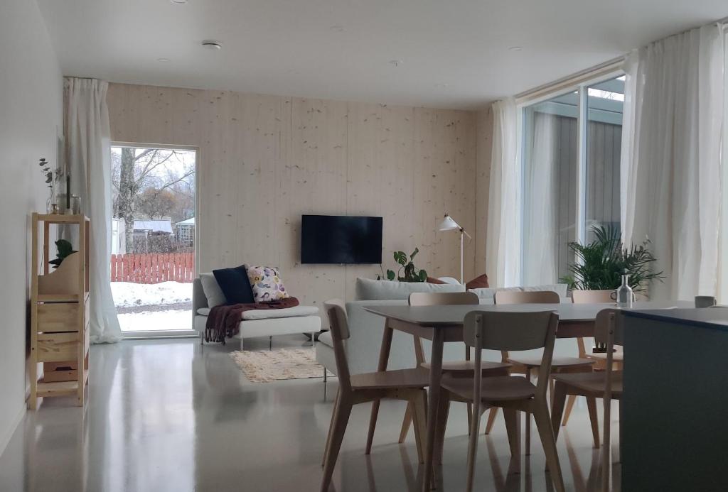 - un salon avec une table et un canapé dans l'établissement New Villa w/sauna, jacuzzi &wifi, à Hämeenlinna