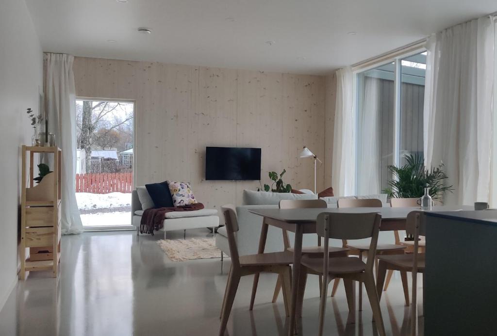 uma sala de estar com uma mesa e um sofá em New Villa w/sauna, jacuzzi &wifi em Hämeenlinna